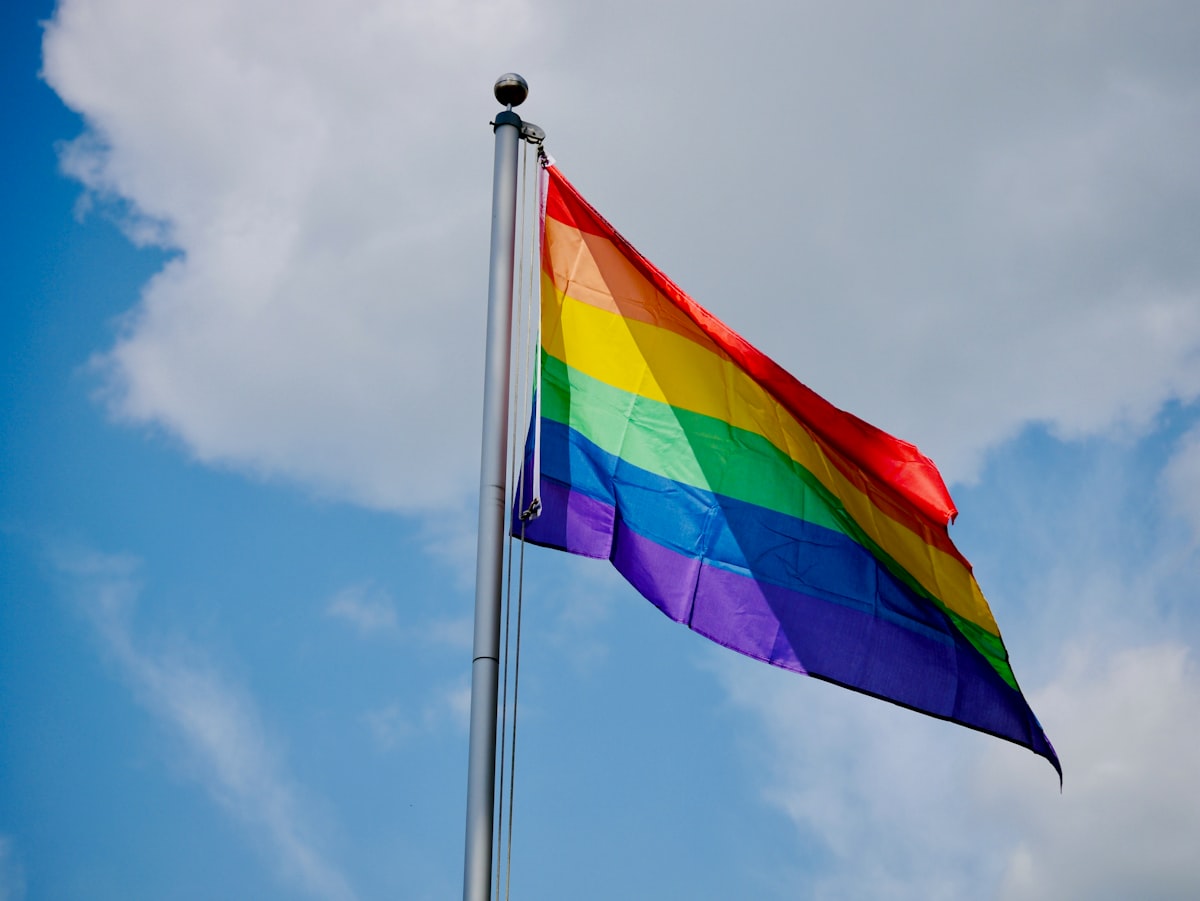 Blue yellow and red striped flag under blue sky during daytime
