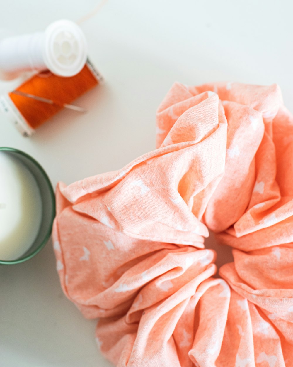 pink textile beside white ceramic mug