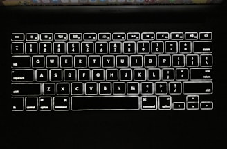 Close-up of a sleek MacBook keyboard illuminated by soft natural light.