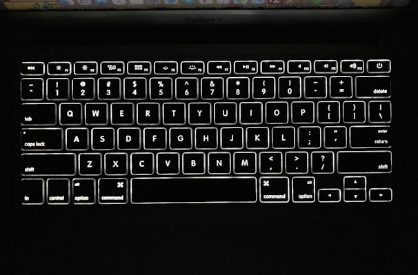 Close-up of a sleek MacBook keyboard illuminated by soft natural light.