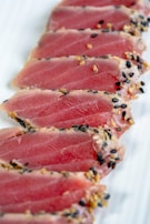 sliced raw meat on white ceramic plate