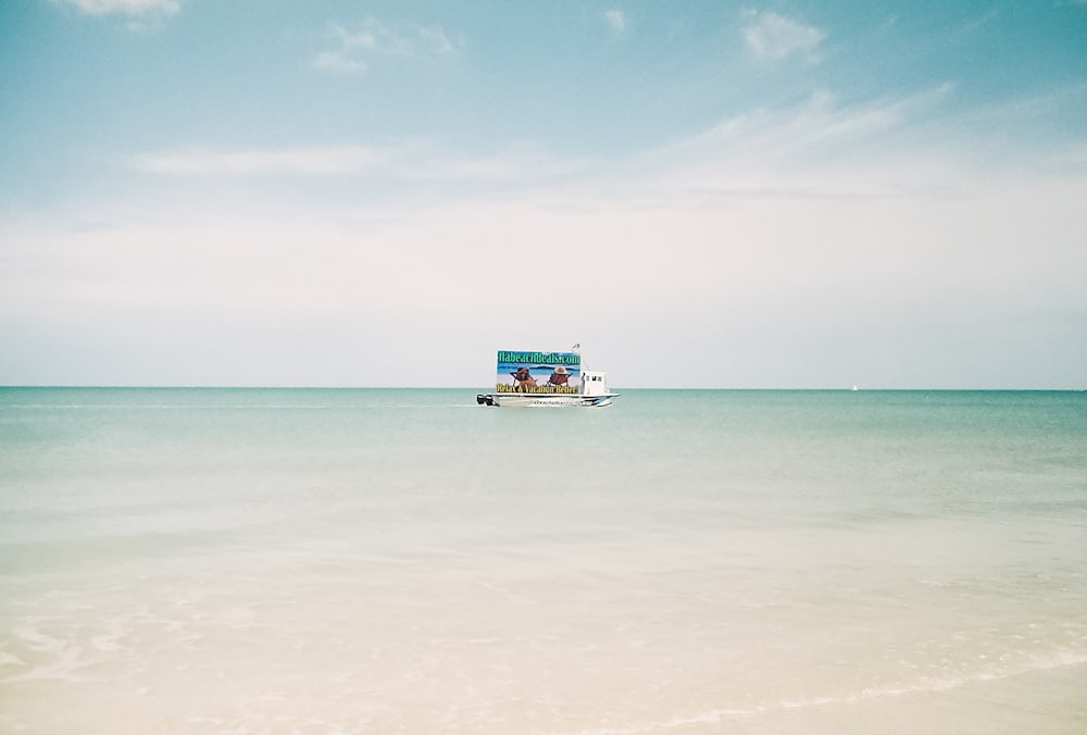 blue and white boat on sea under blue sky during daytime