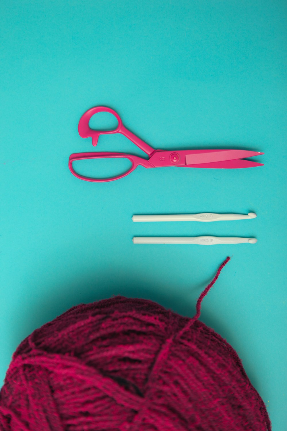 a ball of yarn, a pair of scissors, and a pair of knitting needles