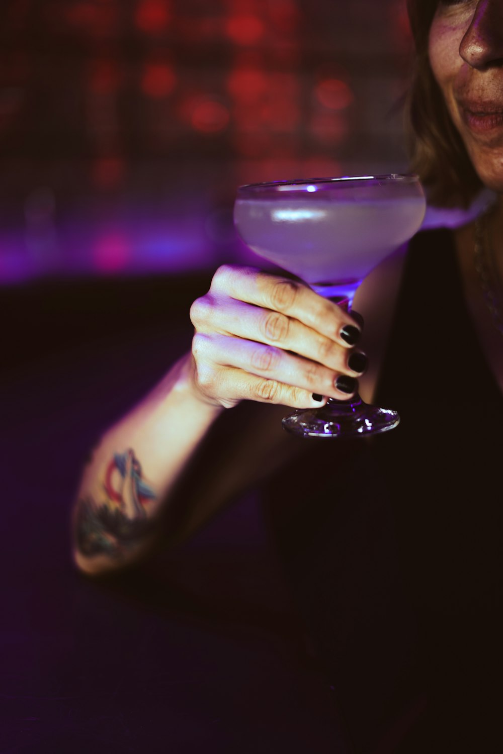 woman holding clear wine glass