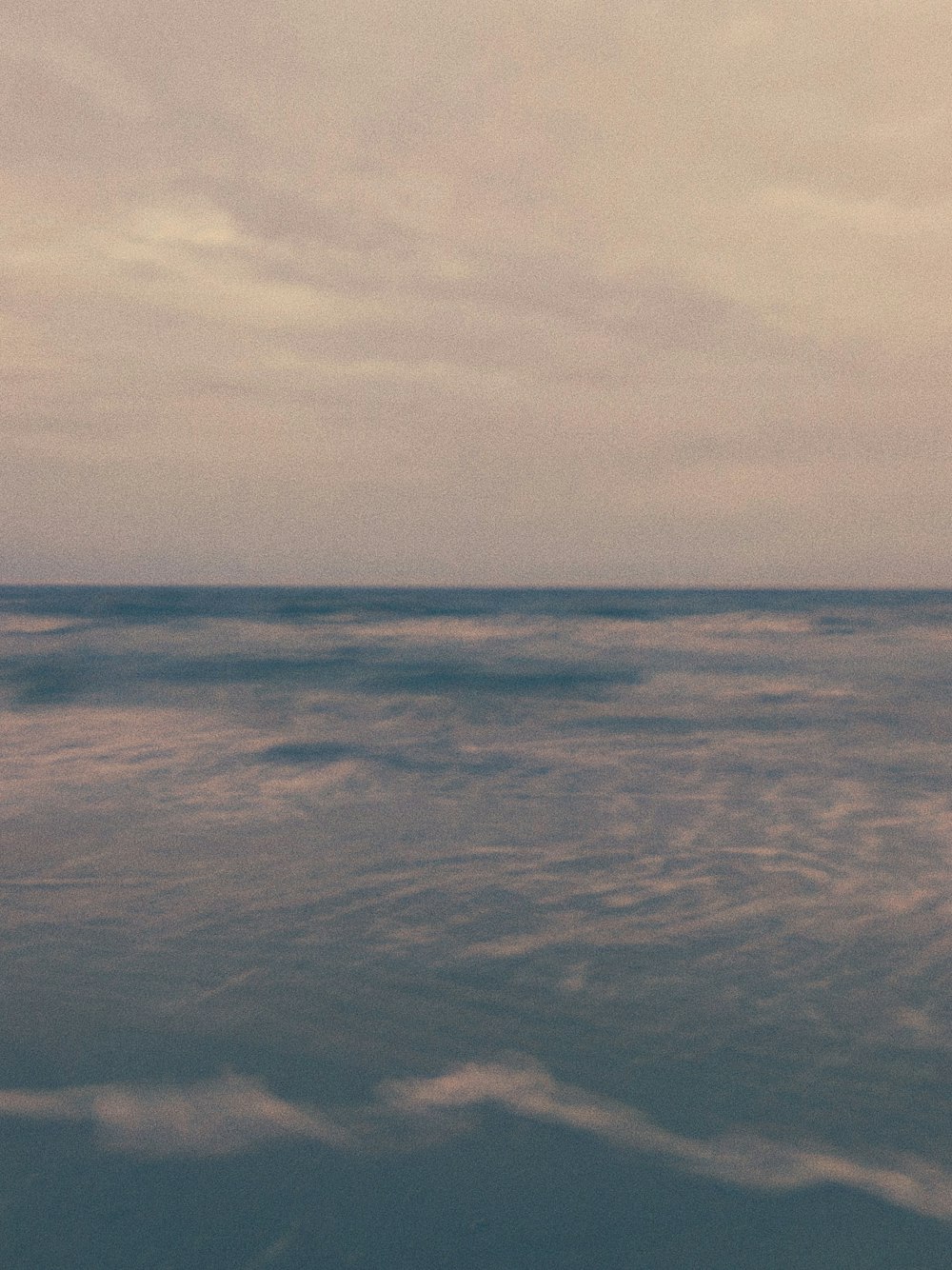 昼間の白い雲の下の青い海