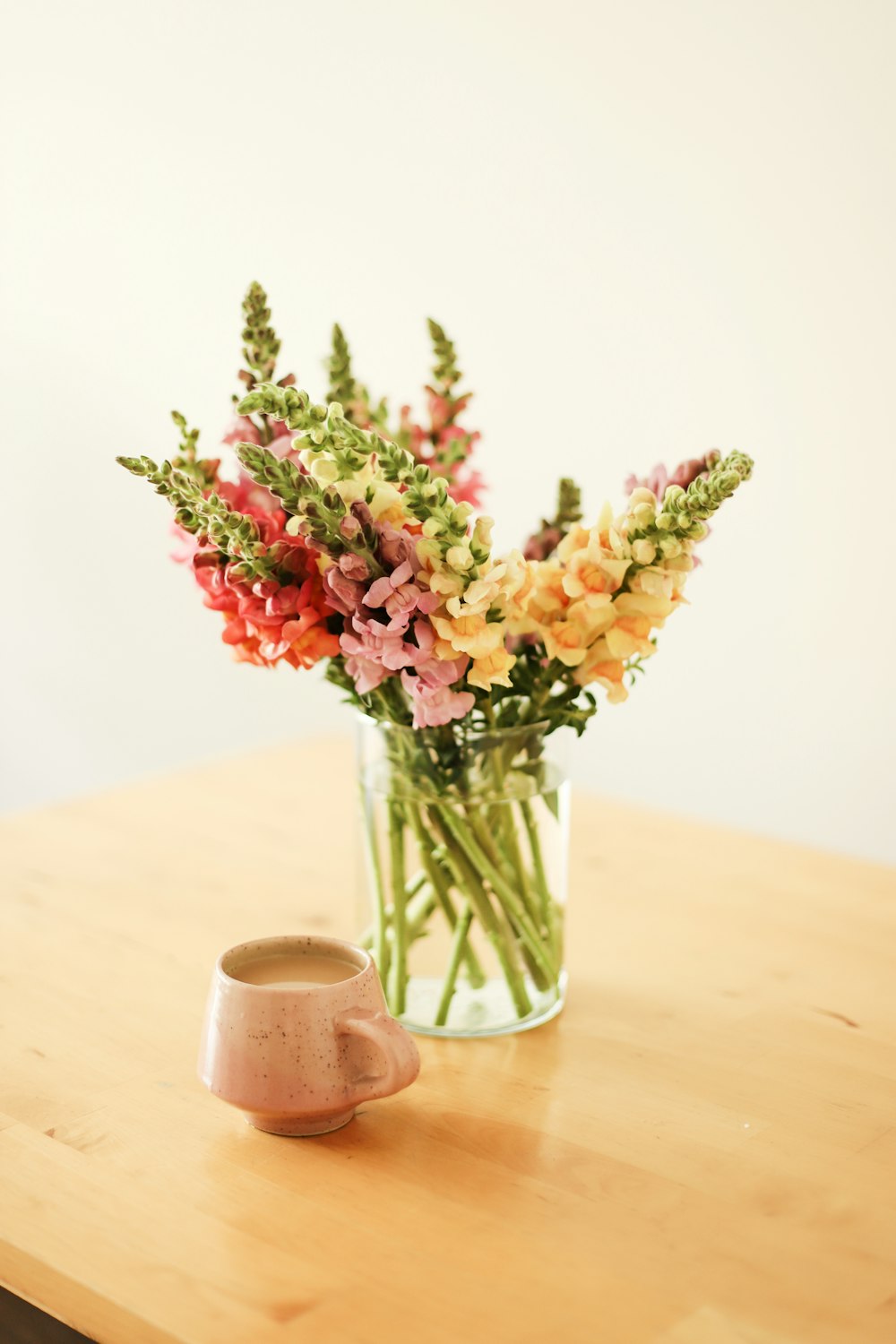 flores vermelhas e amarelas no vaso de vidro transparente