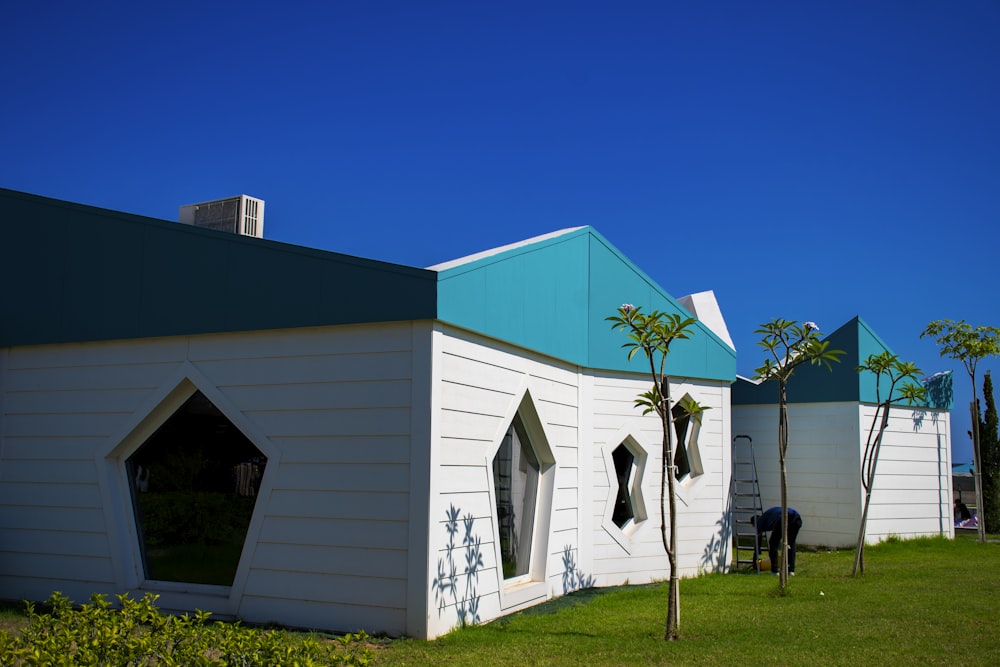 white and blue house near green grass field during daytime