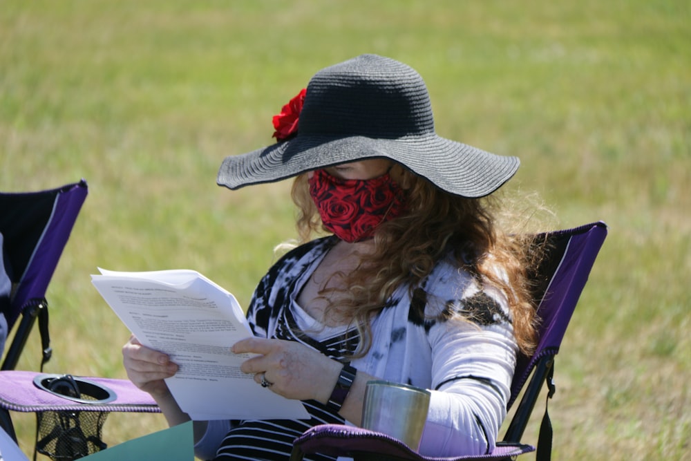 woman in black hat reading book