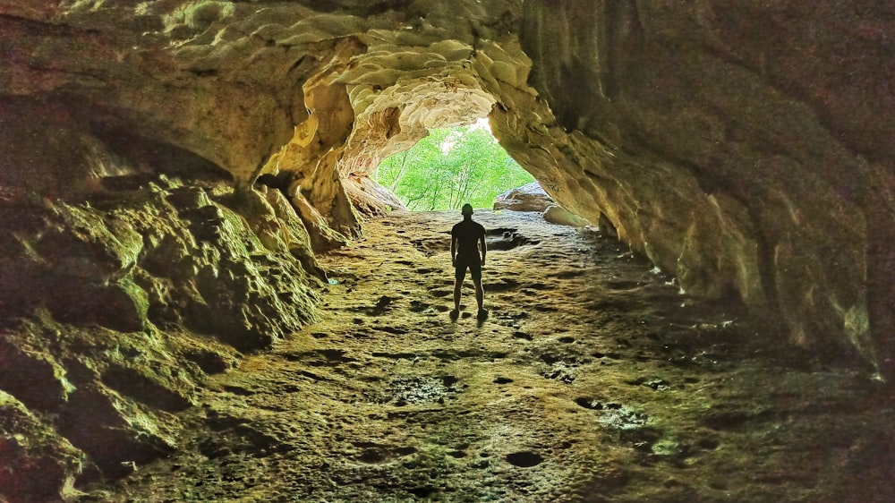 person in black jacket walking on brown rocky road