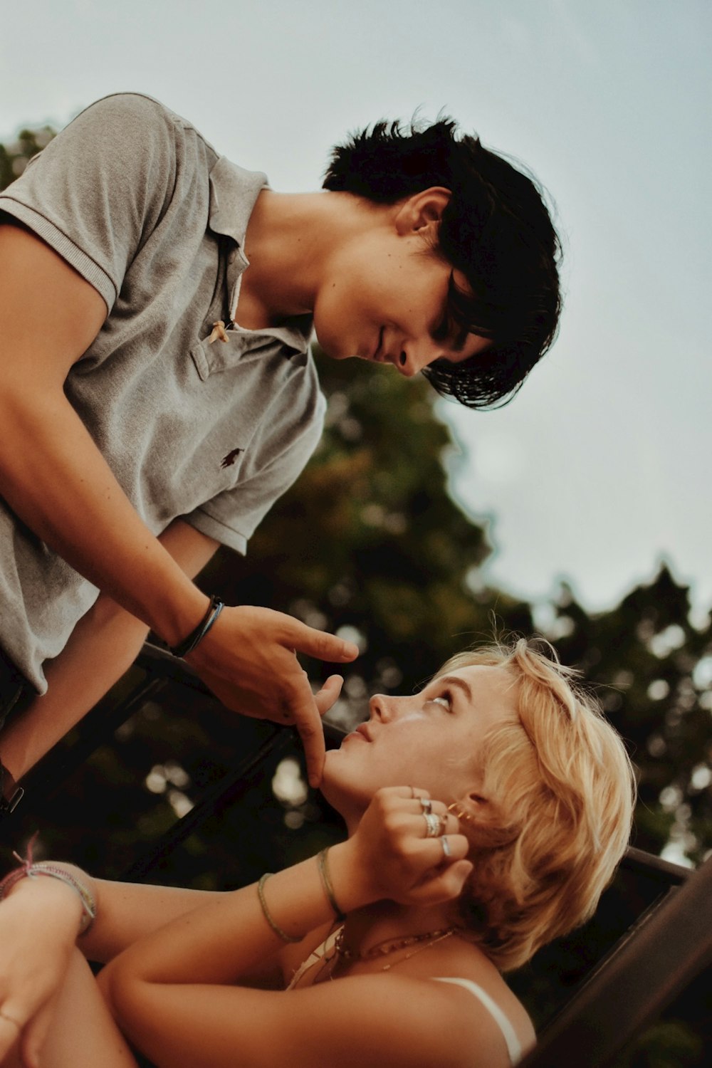 uomo in polo grigia che bacia la donna in camicia grigia durante il giorno