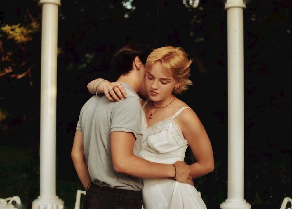 woman in white tank top hugging woman in white sleeveless dress