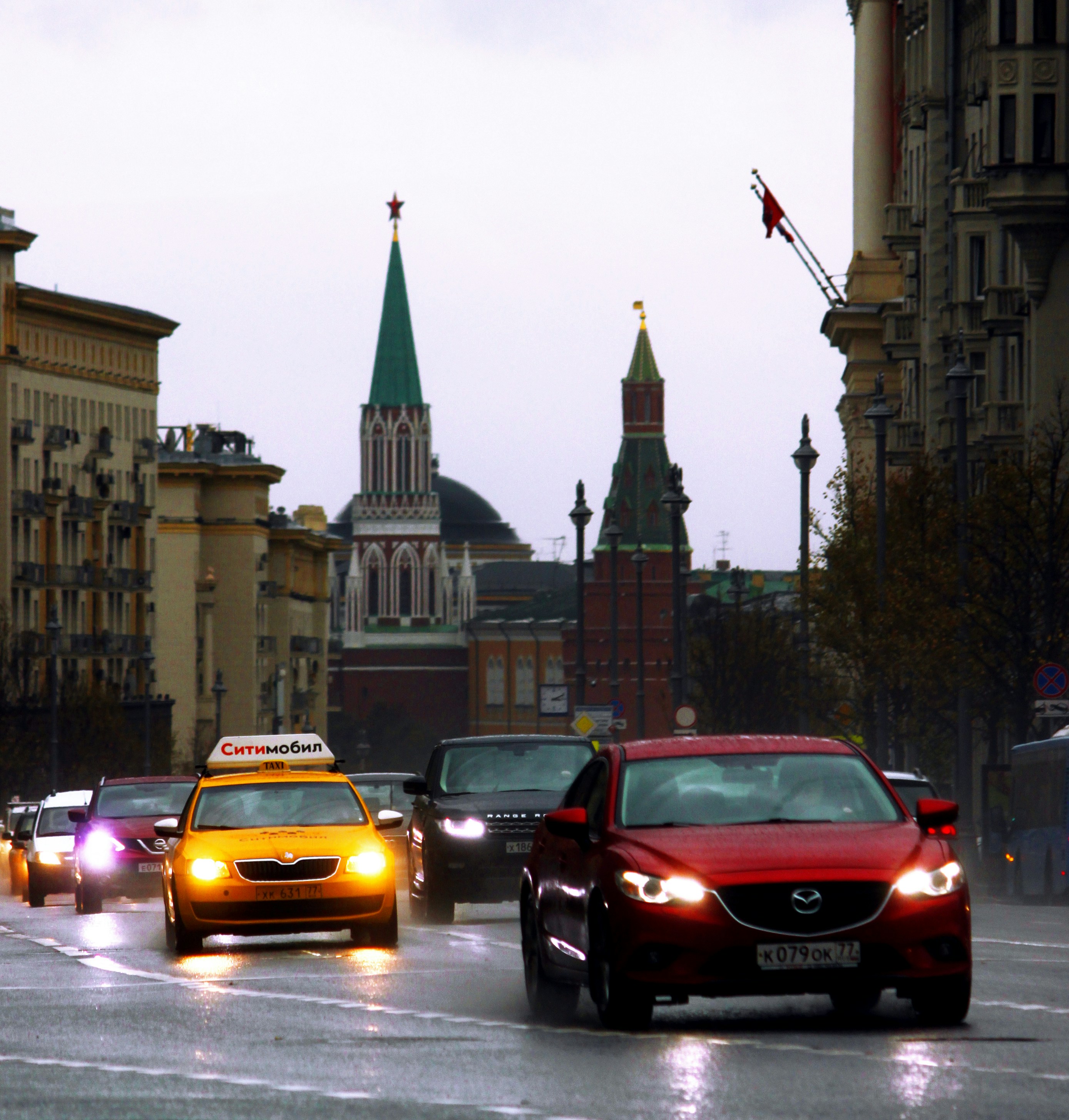 Rotes Auto tagsüber auf der Straße in der Nähe des braunen Betongebäudes