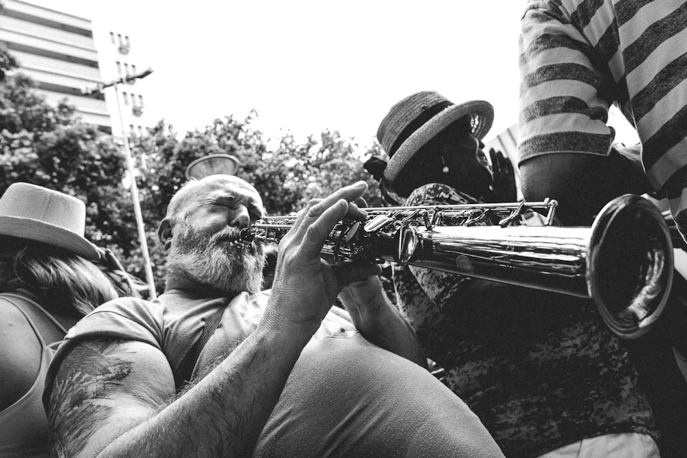 man in white crew neck t-shirt playing trumpet