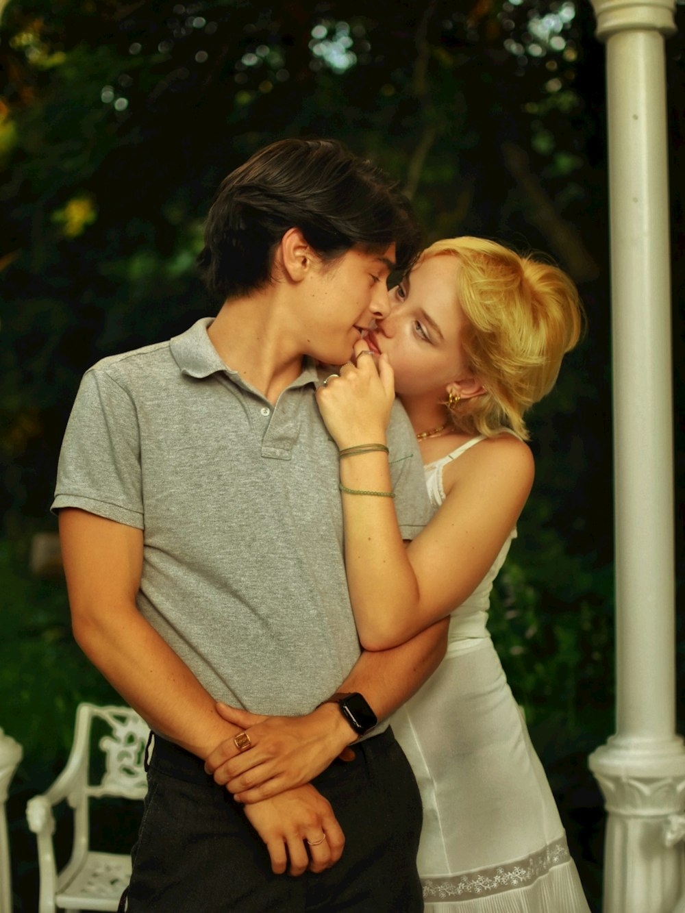 man in gray polo shirt kissing woman in white dress