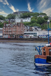 blue and brown boat on water near brown concrete building during daytime