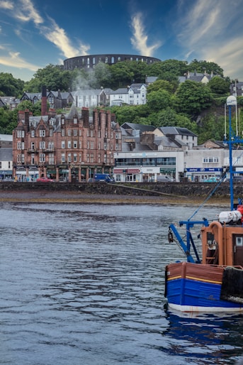 blue and brown boat on water near brown concrete building during daytime