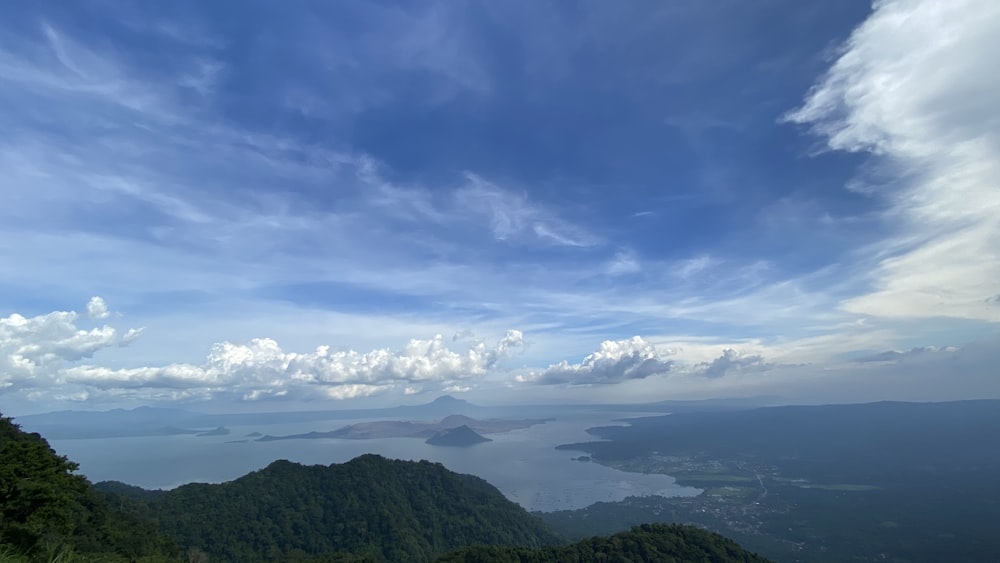 montañas verdes bajo el cielo azul y nubes blancas durante el día