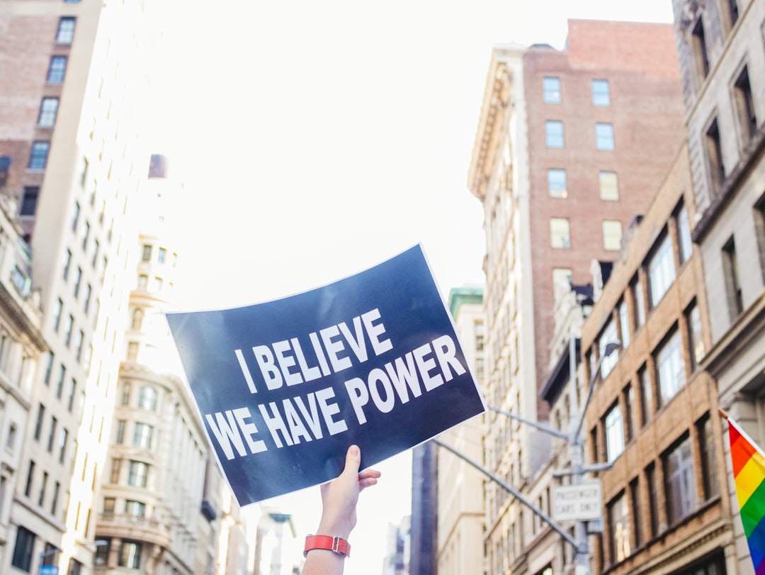 a person holding a sign that says i believe we have power,