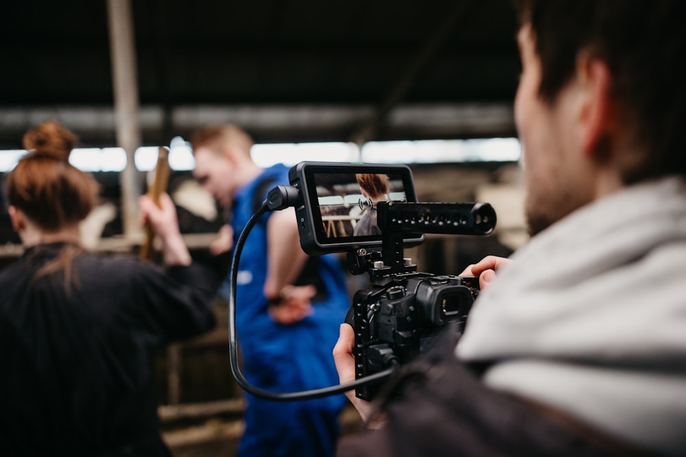 man in black jacket holding black video camera