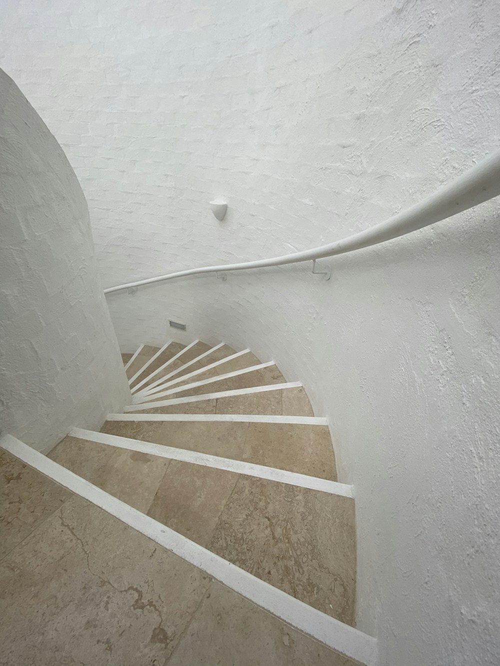 white concrete spiral staircase with white concrete wall
