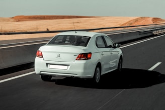 silver sedan on black asphalt road during daytime