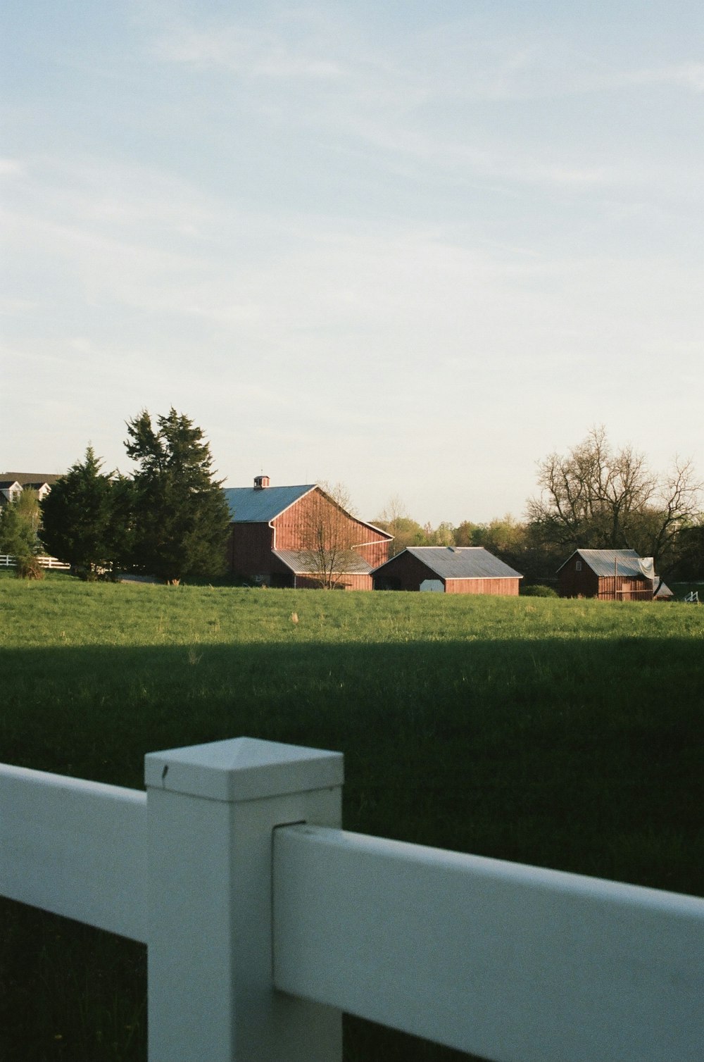 casa de madeira marrom no campo de grama verde sob o céu branco durante o dia