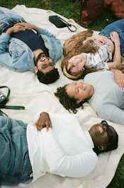 man in blue button up shirt lying on white bed