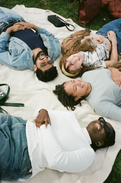 friends laughing together on picnic blanket