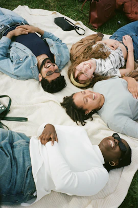 man in blue button up shirt lying on white bed