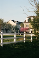 brown and white concrete house near green grass field during daytime