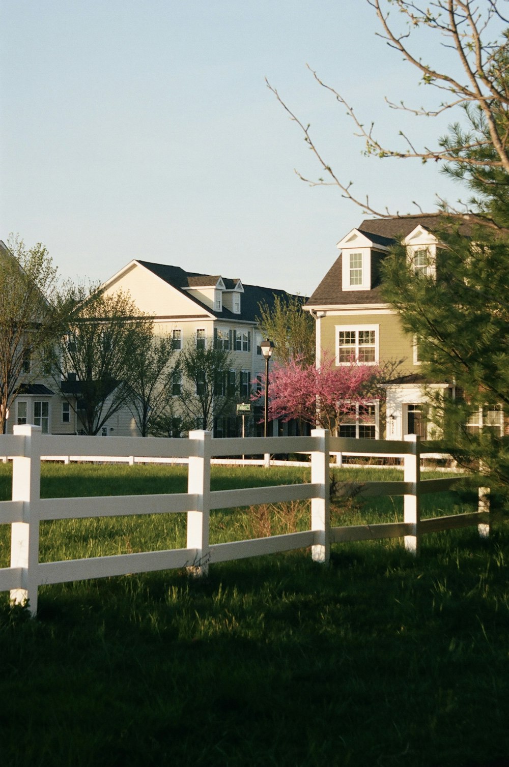 brown and white concrete house near green grass field during daytime