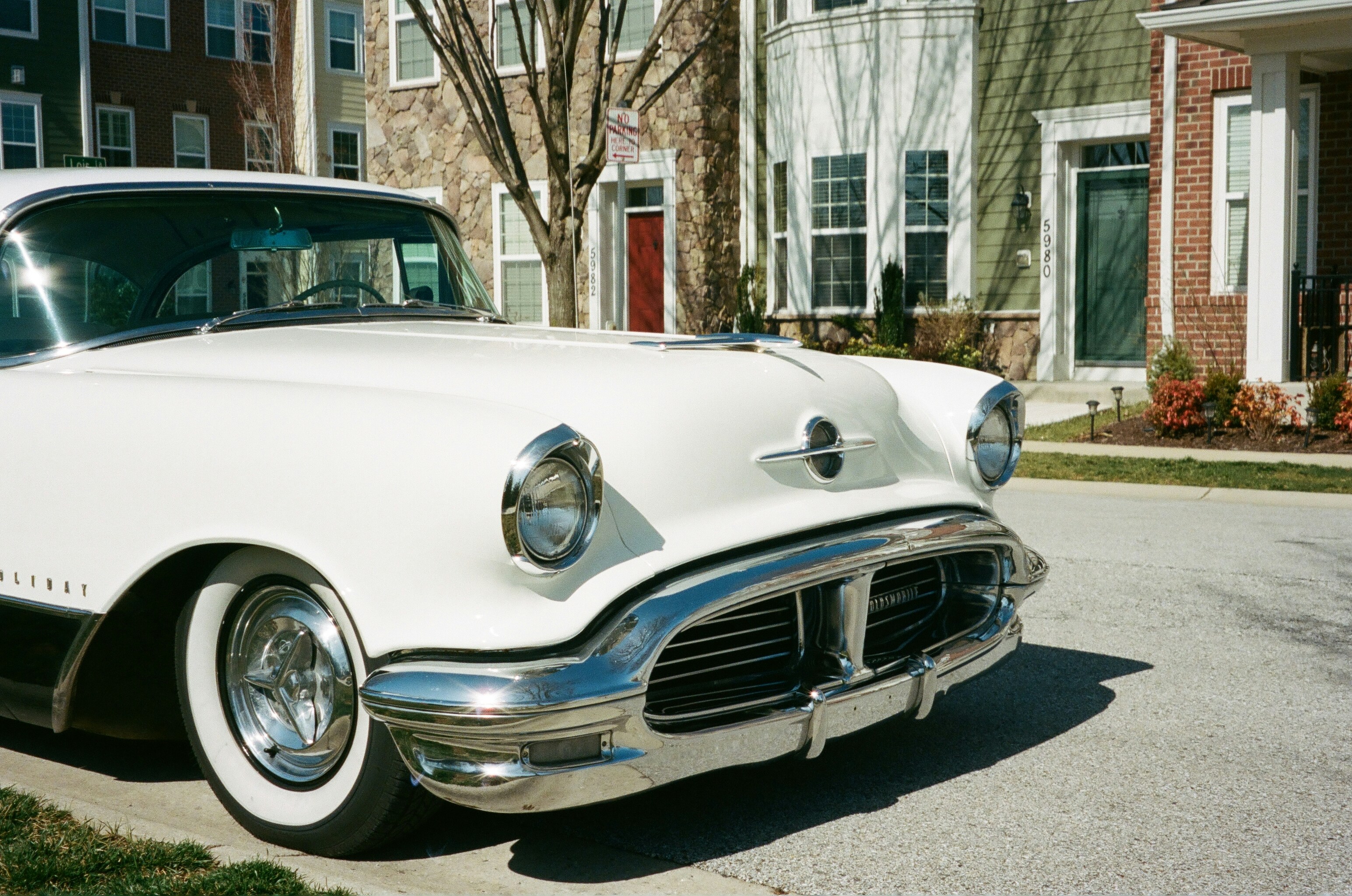 white car parked near brown building during daytime
