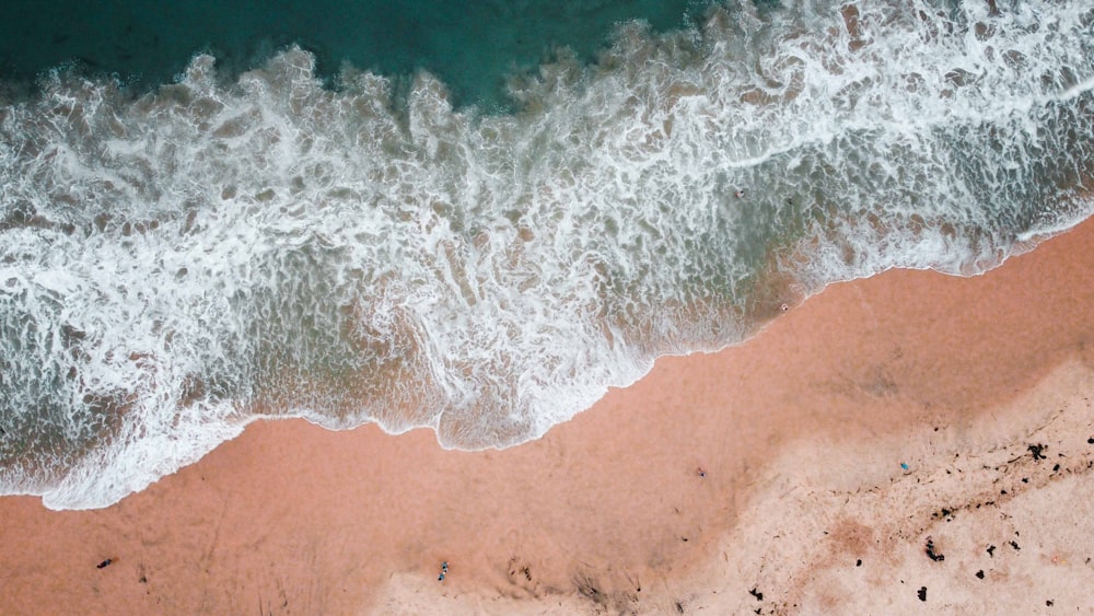 sea waves crashing on shore during daytime