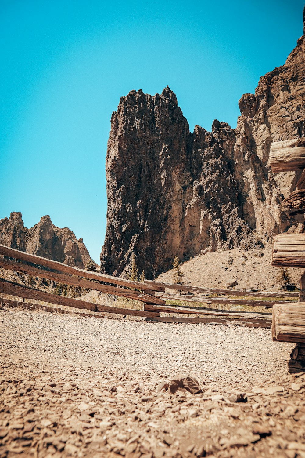 brown wooden fence on gray sand during daytime