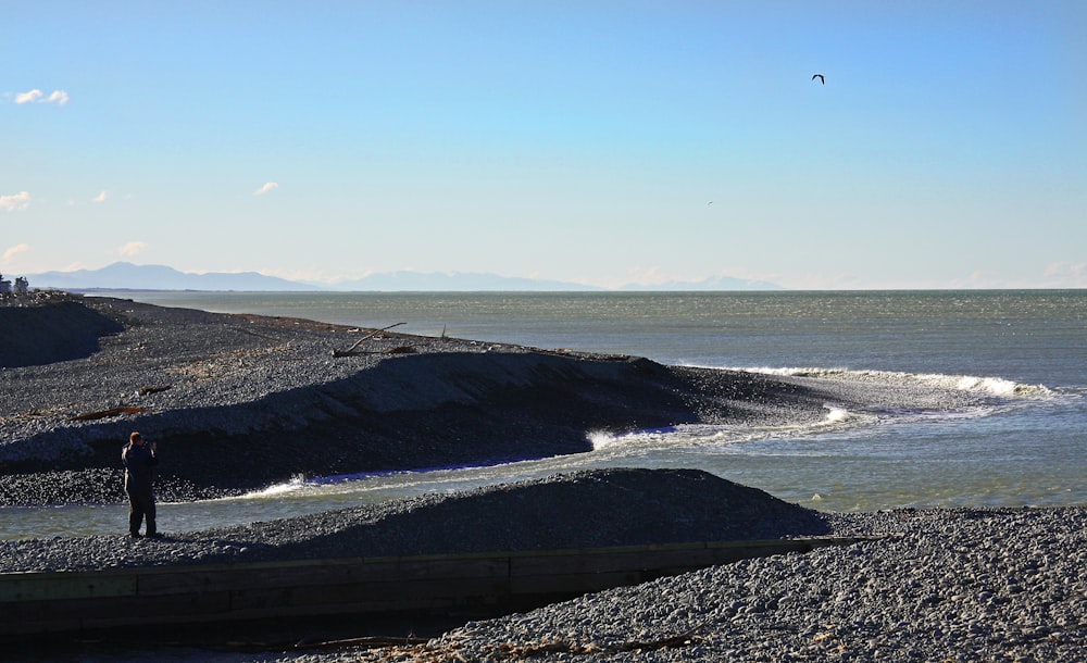 body of water near mountain during daytime