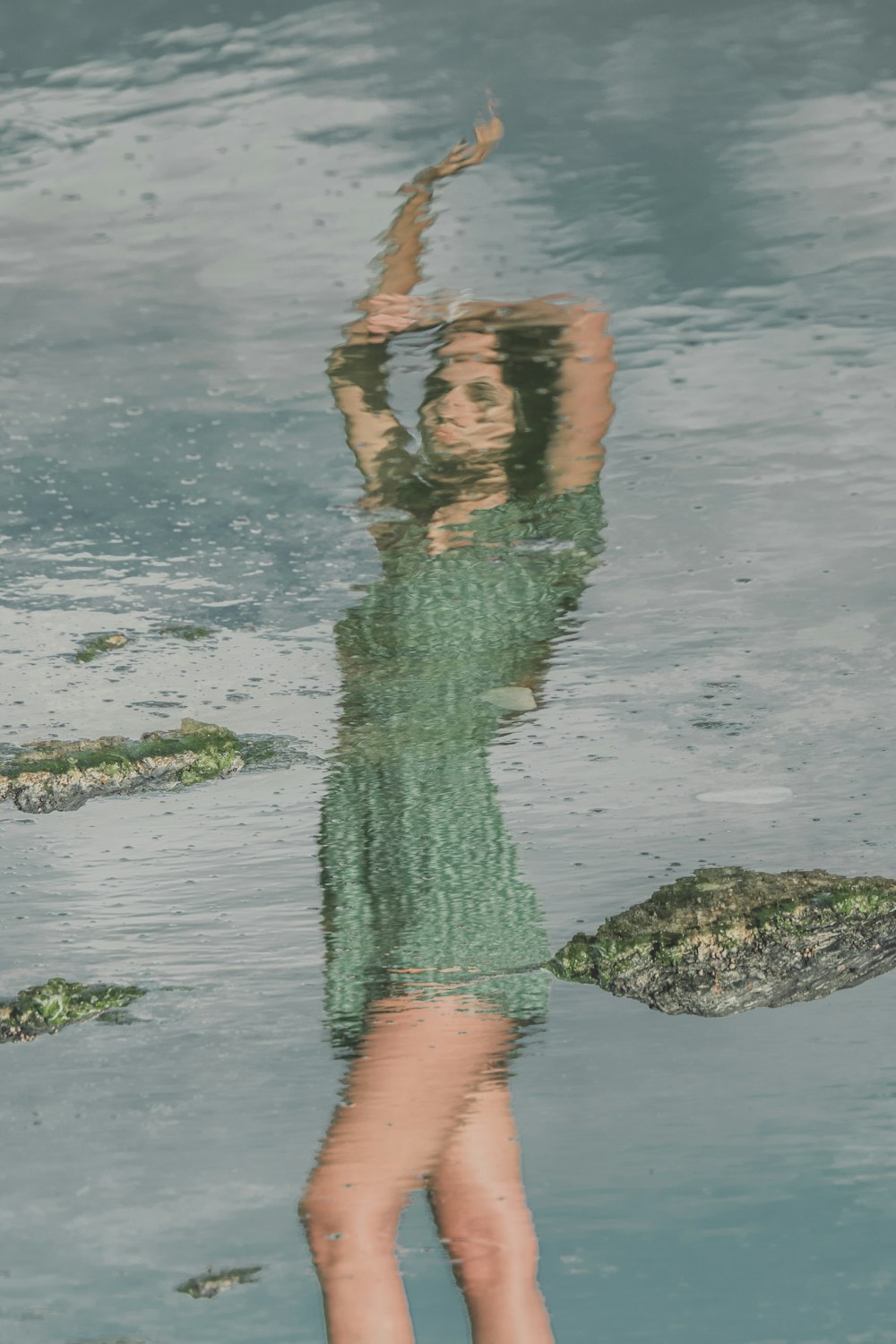 woman in green dress standing on water during daytime