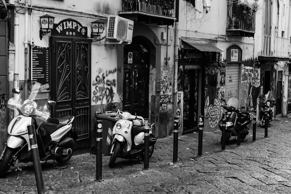 grayscale photo of motorcycle parked beside store