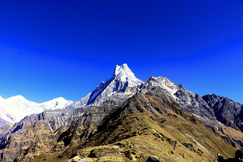 Montagna rocciosa marrone e bianca sotto il cielo blu durante il giorno