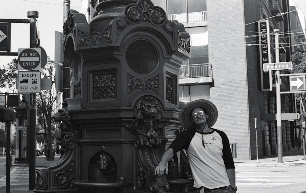 man in white shirt and black pants standing near black statue