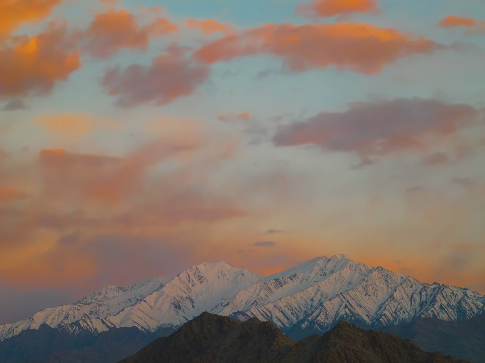 snow covered mountain under cloudy sky during daytime