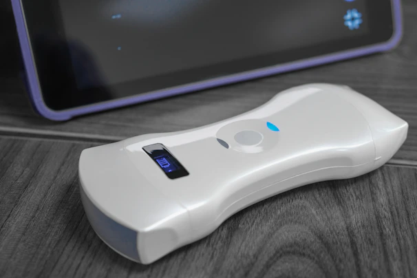 A hand holding a compact, sleek rechargeable battery against a clean white background