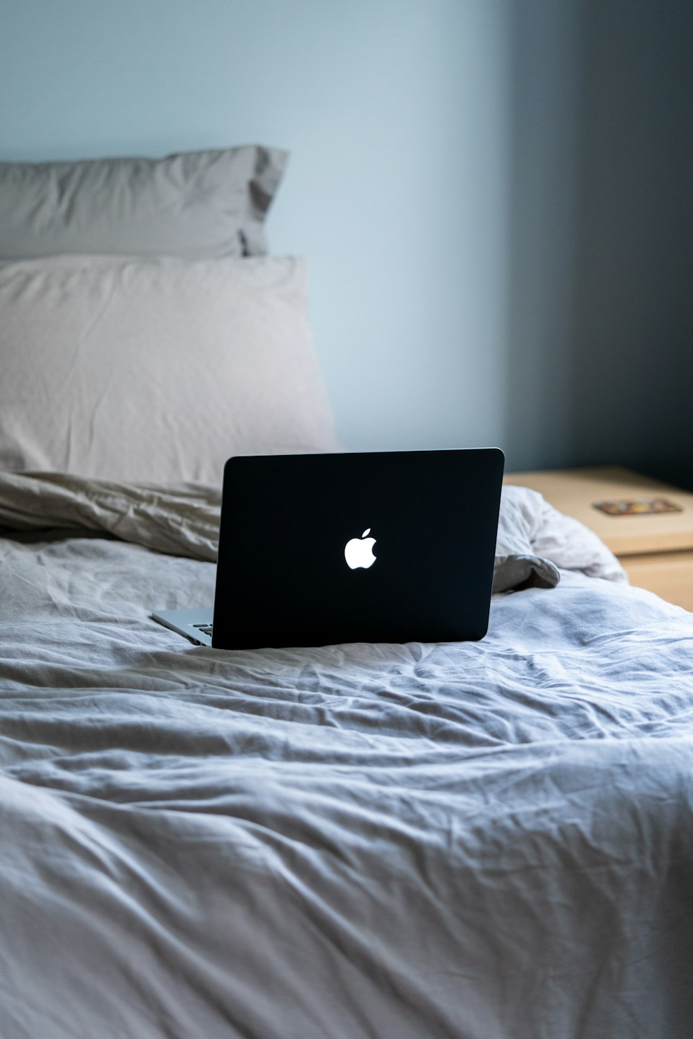 black macbook on white bed