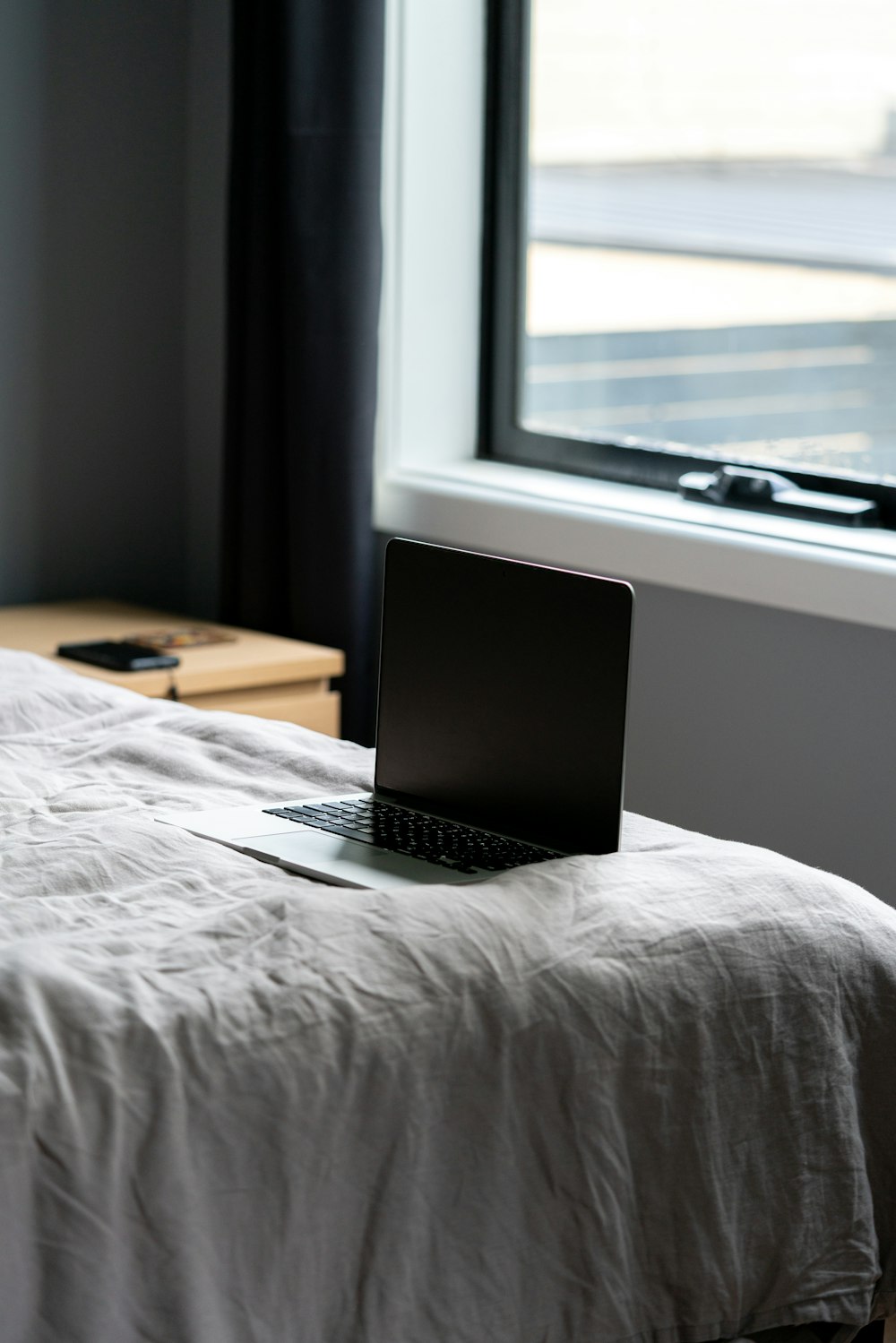 macbook pro on bed near window