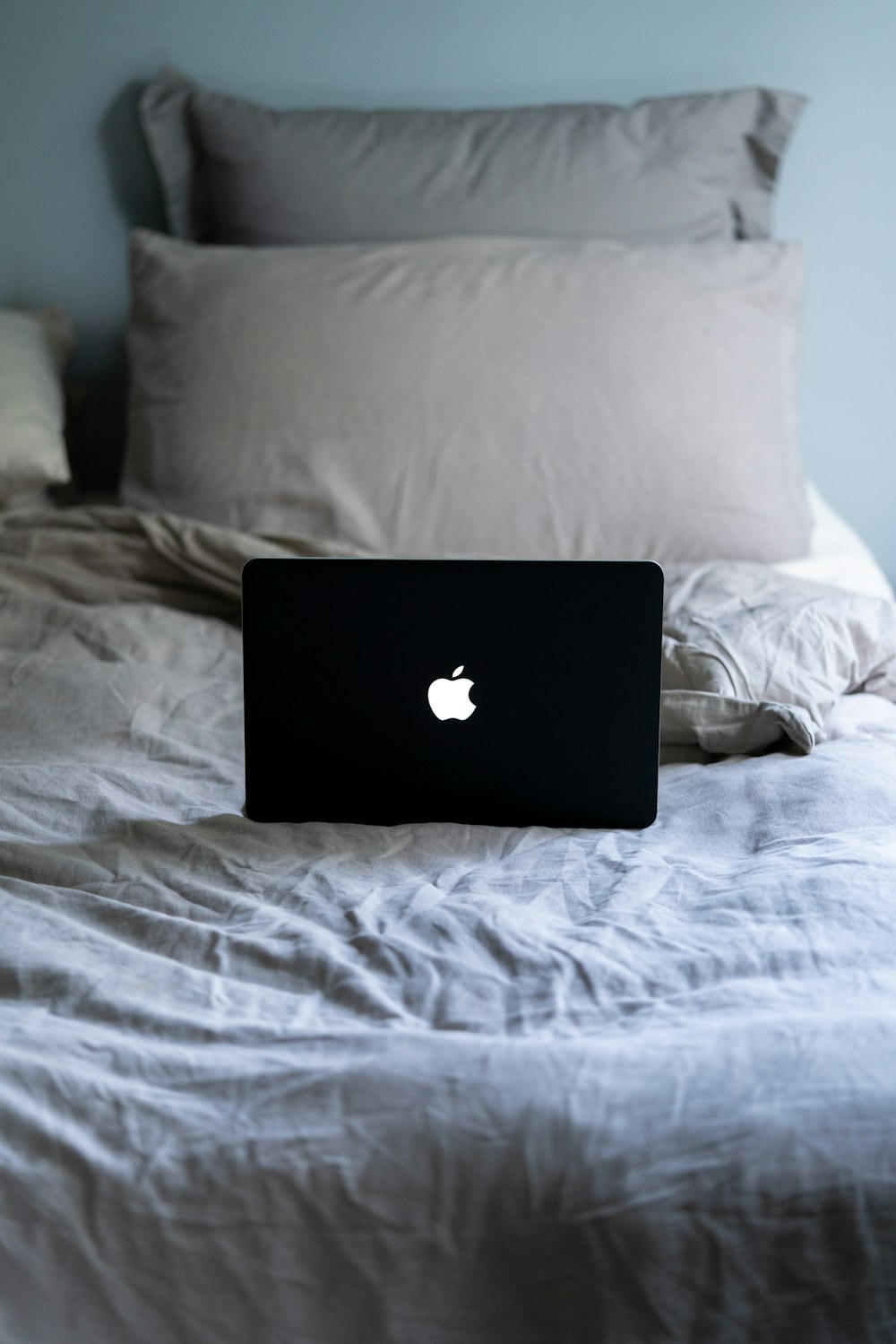 black macbook on white bed