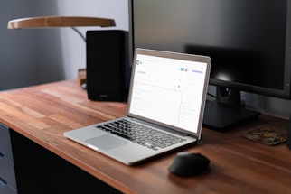 A cozy workspace with a laptop open to a contact form on a warm wooden desk.
