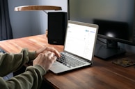 person in gray jacket using macbook pro