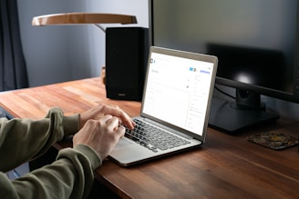 person in gray jacket using macbook pro