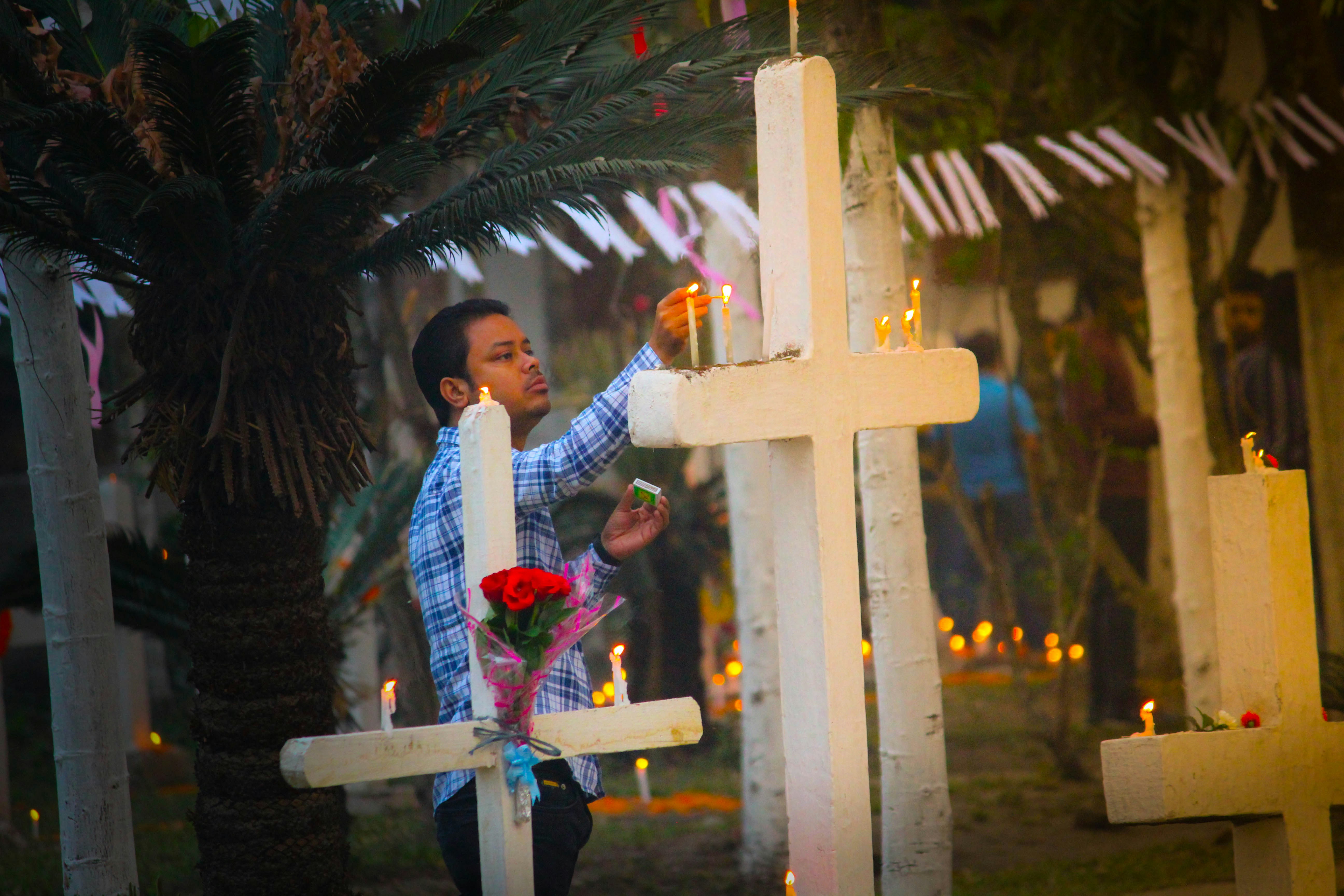 girl in white and red jacket standing beside white cross