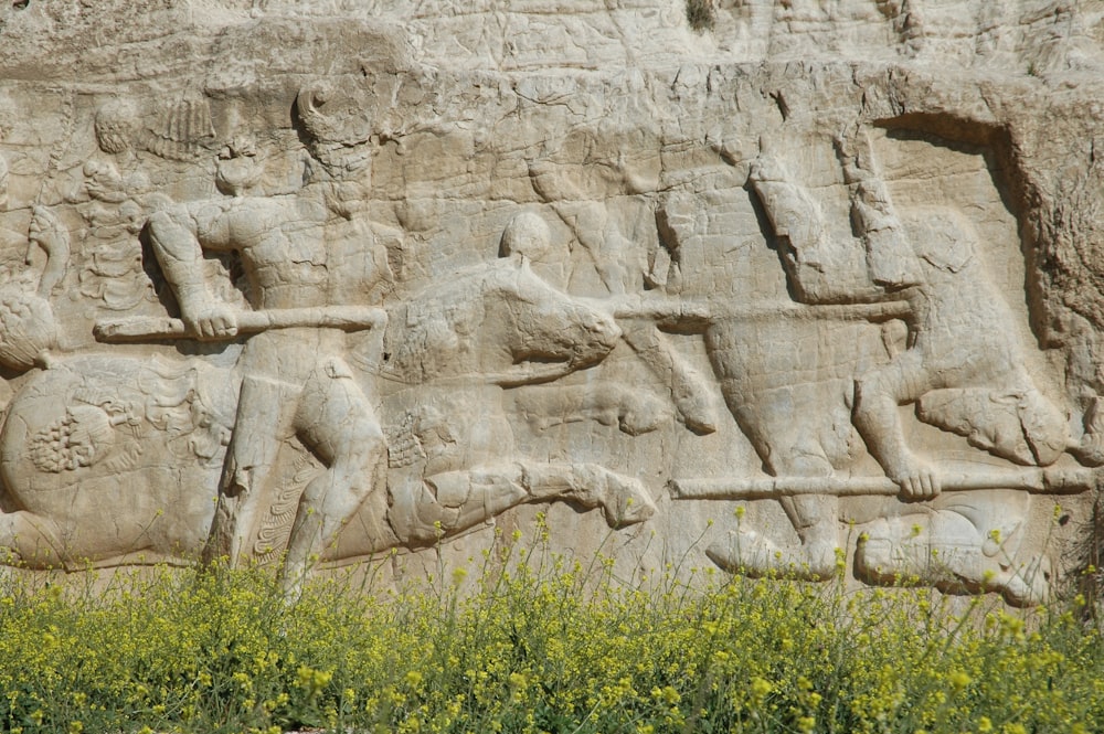 Statue en béton blanc sur l’herbe verte pendant la journée