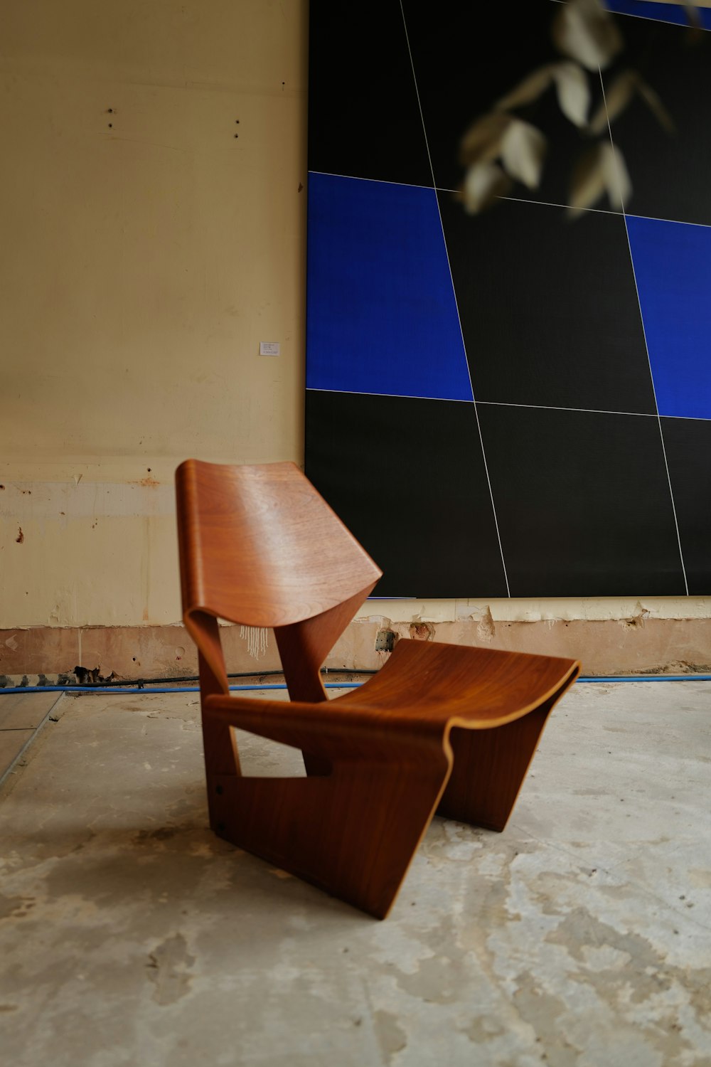 brown wooden chair beside blue and white wall